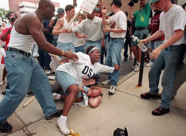 june-22-1996-e28093-then-18-year-old-keshia-thomas-of-ann-arbor-shields-a-man-wearing-a-confederate-t-shirt-from-an-angry-crowd-during-a-ku-klux-klan-rally-outside-ann-arbor_s-city-hall