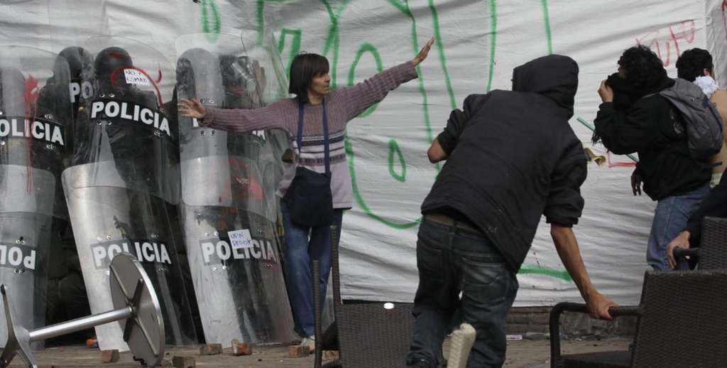 woman-successfully-defends-a-group-of-cornered-riot-officers-from-angry-protesters-bogotc3a1-colombia-2013